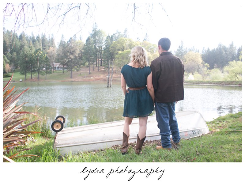 Bride and groom by boat at lifestyle engagement portraits at a lake in Grass Valley, California