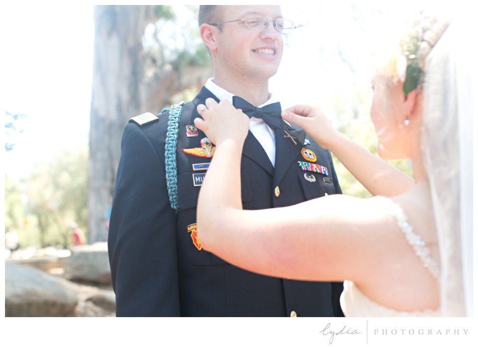Bride fixing groom's army ranger bow tie at ethereal wedding in Santa Rosa, California