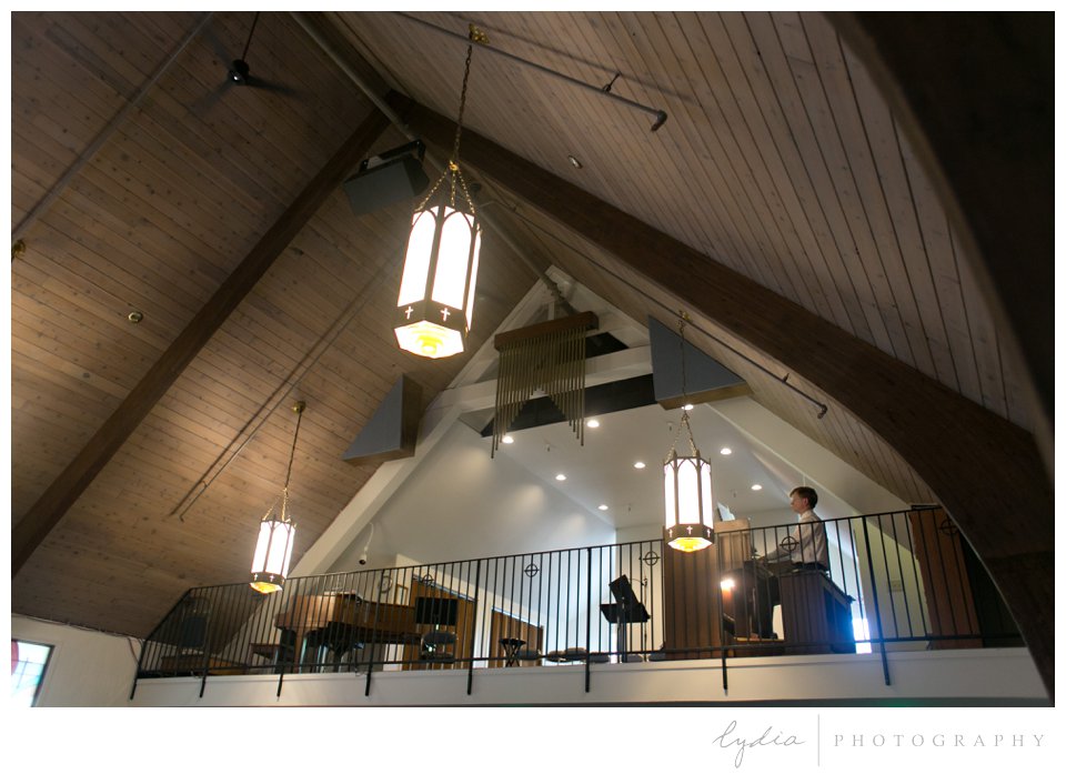 Father of the groom playing the organ for the wedding ceremony at St Mark in Santa Rosa California.
