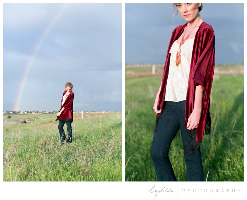 Anthropologie styled senior wearing a red kimono in a field with a rainbow in Roseville, California at William Jessup University.