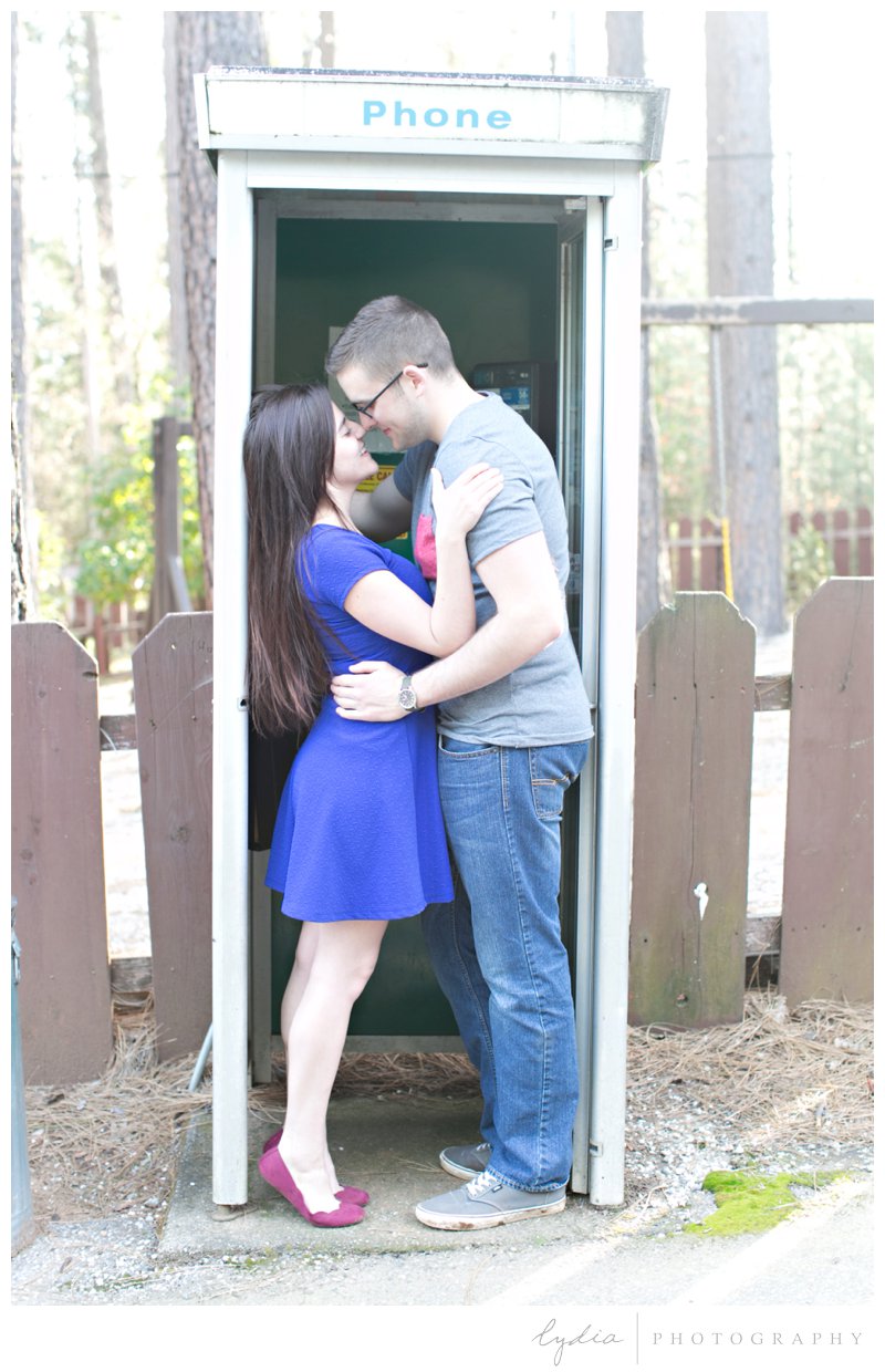 Bride and groom by a old telephone booth at a Tahoe Forest engagement session at the Tahoe National Forest and at Scotts Flat Lake in Nevada City, California.