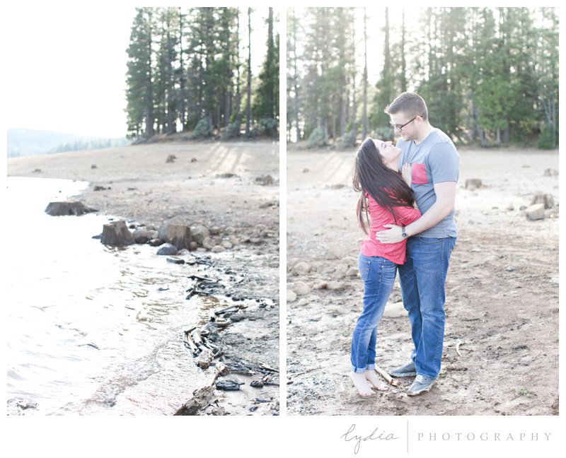 Bride and groom hugging at a lake at a woodsy, nature engagement session at the Tahoe National Forest and at Scotts Flat Lake in Nevada City, California.
