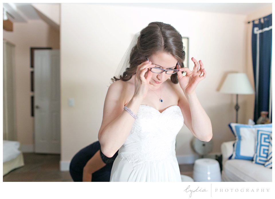 Bride putting on her glasses at Harmony Ridge Lodge Jewish wedding in the Tahoe National Forest in California.