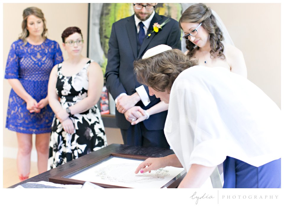 Reading aloud the Ketubah agreement at Harmony Ridge Lodge Jewish wedding in the Tahoe National Forest in California.