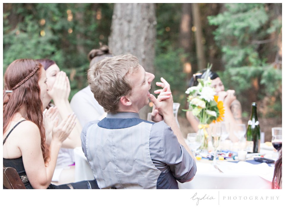 Guests laughing at toasts at Harmony Ridge Lodge Jewish wedding in the Tahoe National Forest in California.