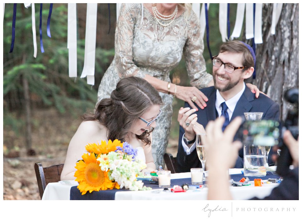 Bride and Groom laughing at toasts at Harmony Ridge Lodge Jewish wedding in the Tahoe National Forest in California.