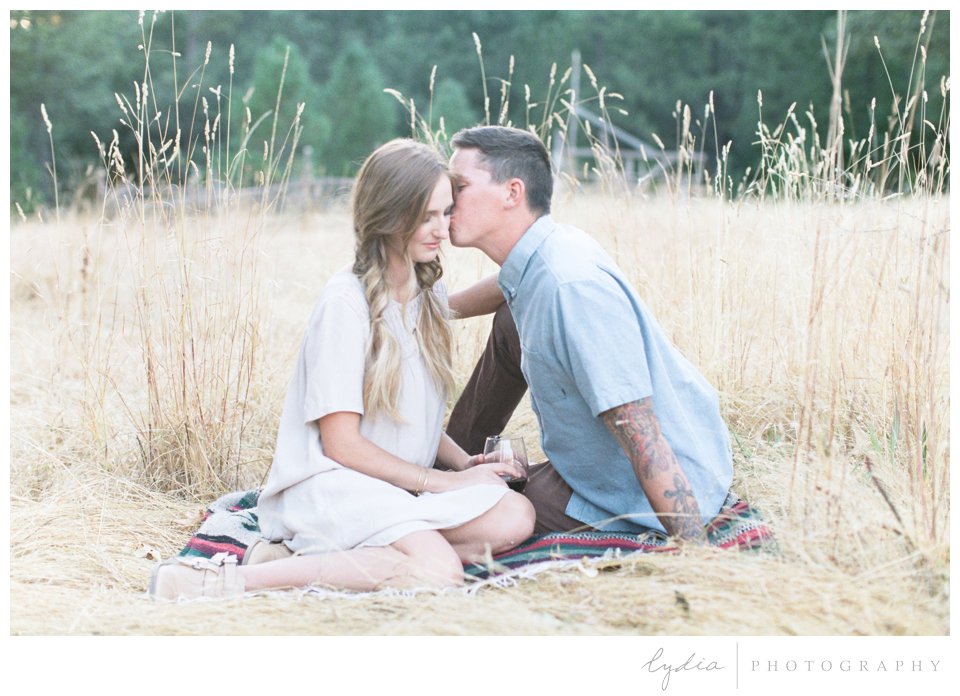 Kissing in field at Smith Vineyard wedding anniversary portrait shoot in Grass Valley, California.