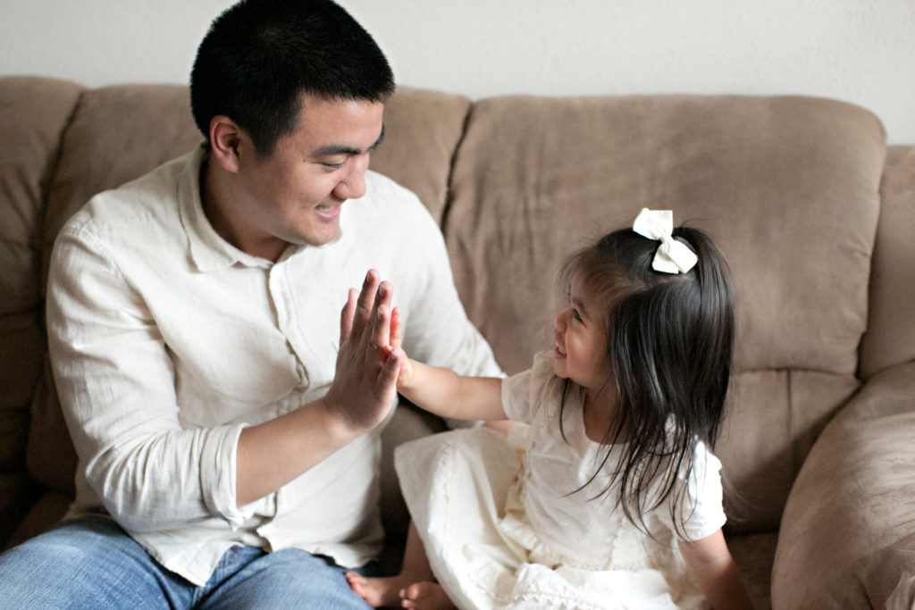 Dad and daughter doing secret handshake at Sacramento lifestyle family portraits