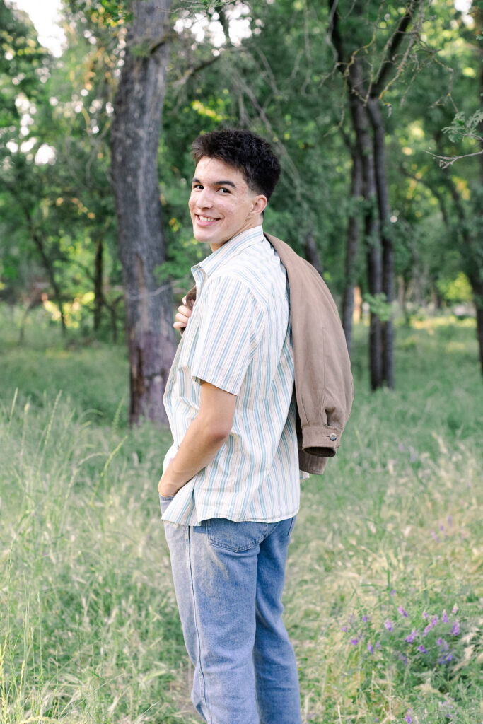 Young man holding jacket at Roseville senior portrait session.