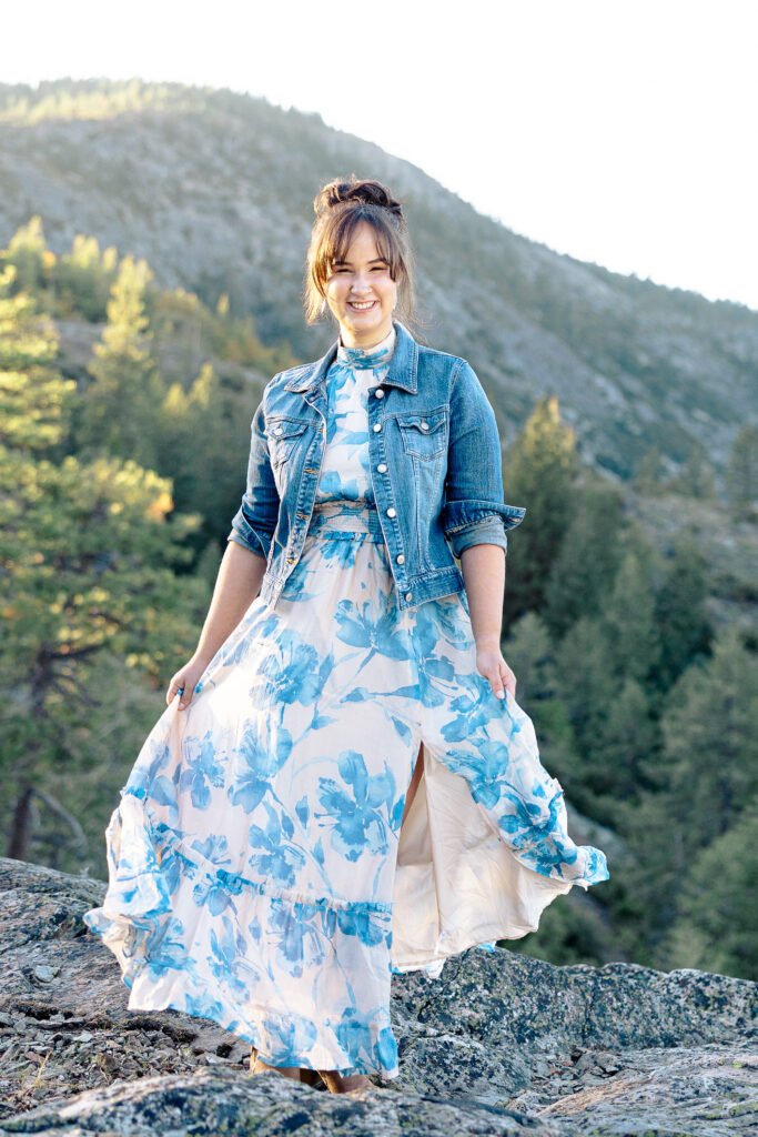 Teen girl smiling and swishing skirt on mountain at Nevada City senior portrait session.