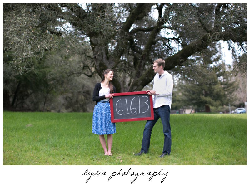 Bride and groom with chalkboard sing engagement portraits at Ragle Ranch Park in Sebastopol, California in Napa Valley