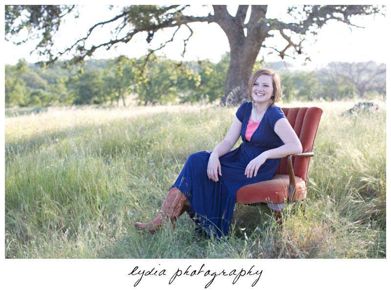 Sitting in a chair in a field for lifestyle senior portraits in Smartsville, California