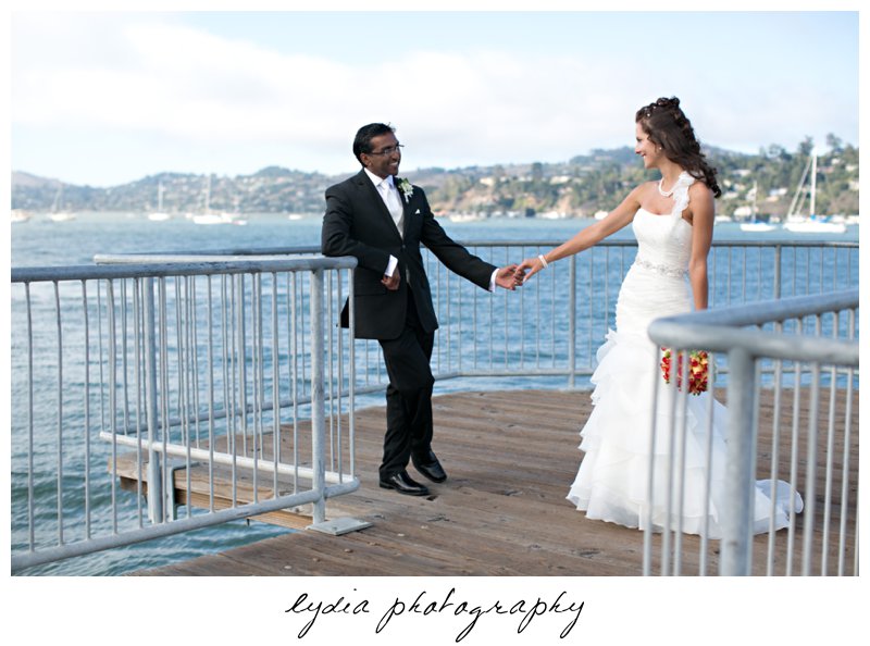 Bride and groom along the shoreline at elegant Sausalito, California wedding at The Spinnaker