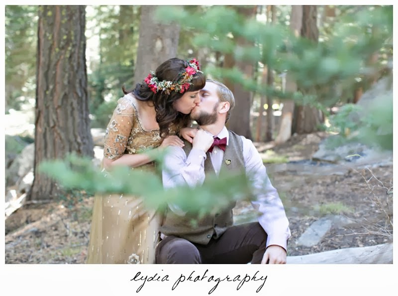 Bride wearing Anthropologie gold dress kissing groom at intimate rustic vintage woodland wedding in Tahoe, California