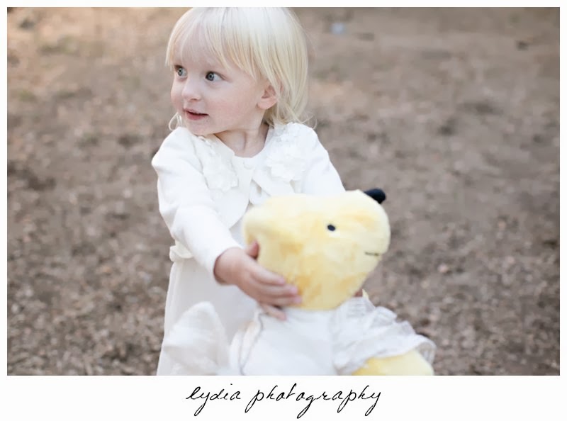 Flowergirl with teddy bear Anthropologie gold dress at intimate rustic vintage woodland wedding in Tahoe, California