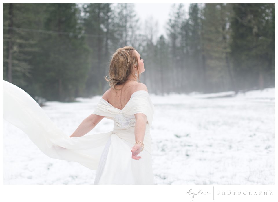 bride in the snow looking up at the sky like Elsa from Frozen