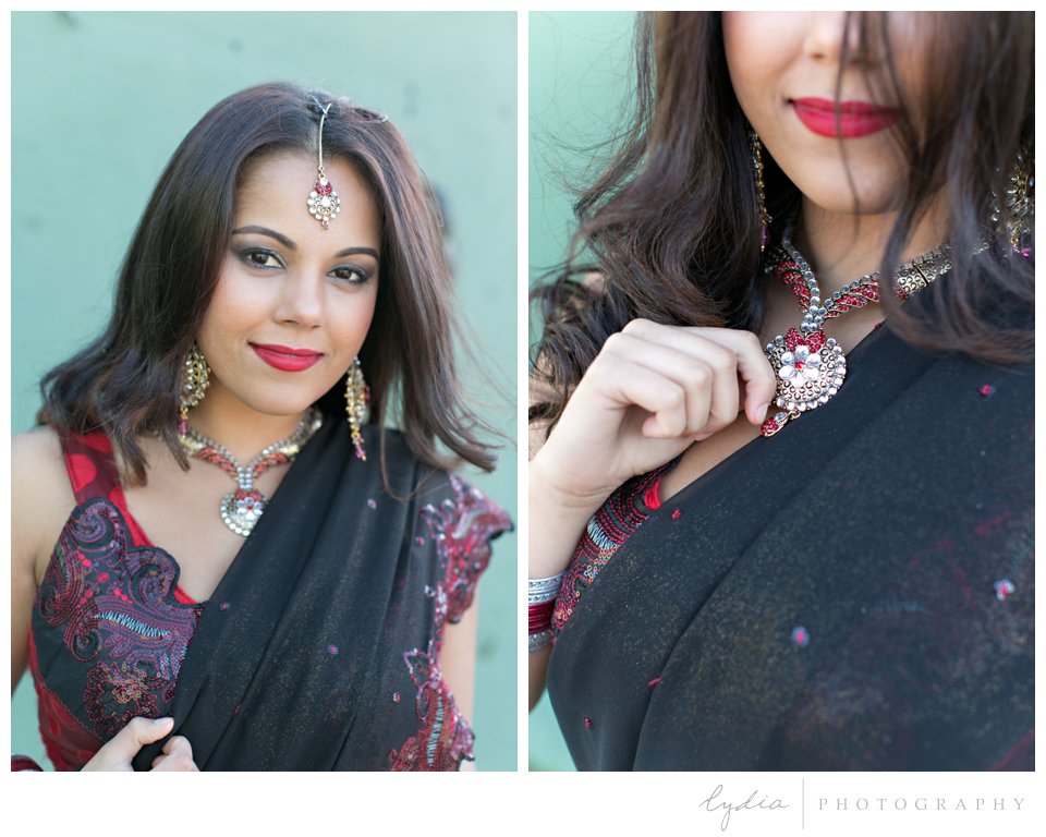 Indian bride wearing red sari and gold bindi holding necklace at Point Bonita