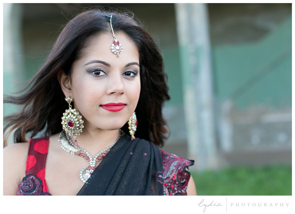 Indian bride wearing red sari and gold bindi