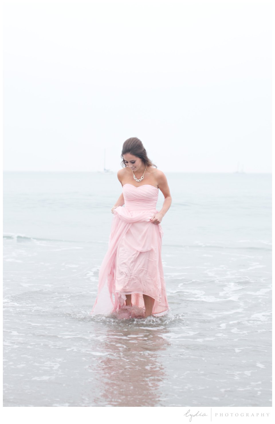 Bride in pink wedding dress in the ocean at a trash the dress shoot in Santa Barbara, California