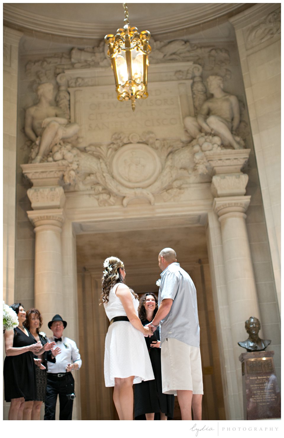 Bride and groom in the rotunda at black and white City Hall wedding in San Francisco, California