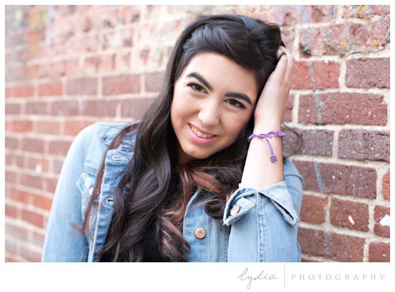 Senior girl infront of the brick building for lifestyle senior portraits at Nevada City