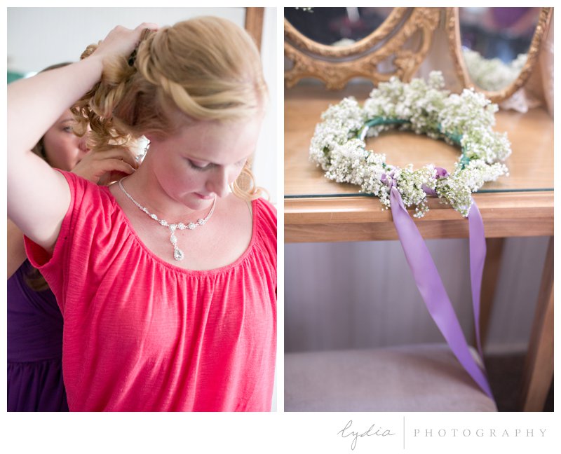 Bride putting on a necklace and a floral crown at Empire Mine fairytale wedding in Grass Valley, California 