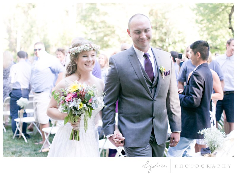 Bride and groom coming down the aisle at a garden wedding at Schrammsberg Estate in Grass Valley, California