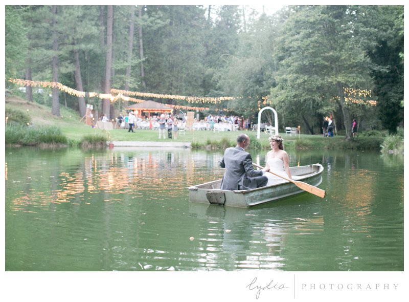 Bride and groom in a boat on the pond at a garden wedding at Schrammsberg Estate in Grass Valley, California