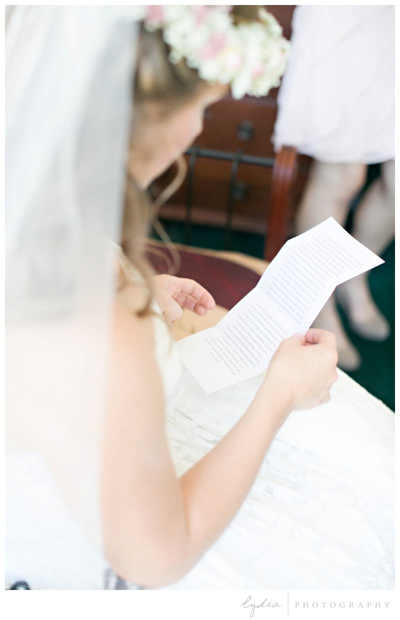 Bride reading a letter from the groom at a garden wedding at Schrammsberg Estate in Grass Valley, California