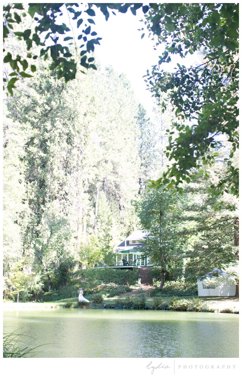 Bride overlooking a pond at a garden wedding at Schrammsberg Estate in Grass Valley, California