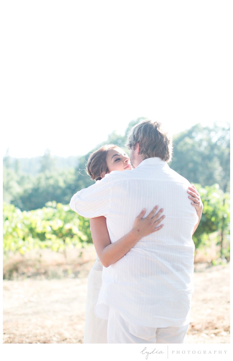 Bride and groom kissing in the vineyard for a vintage wedding at Lucchesi Vineyards in Grass Valley, California.