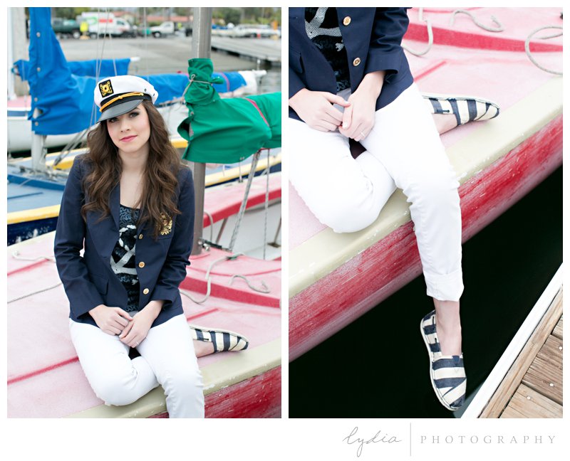 Senior sitting on a red boat for a nautical senior's styled inspiration portraits in Santa Barbara, California.