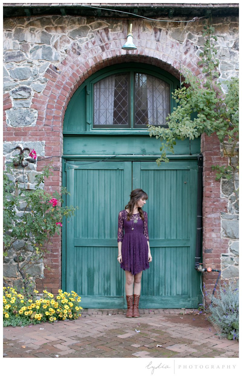 Grass Valley photographer in front of a green, wooden door for lifestyle portraits at Empire Mine in California.