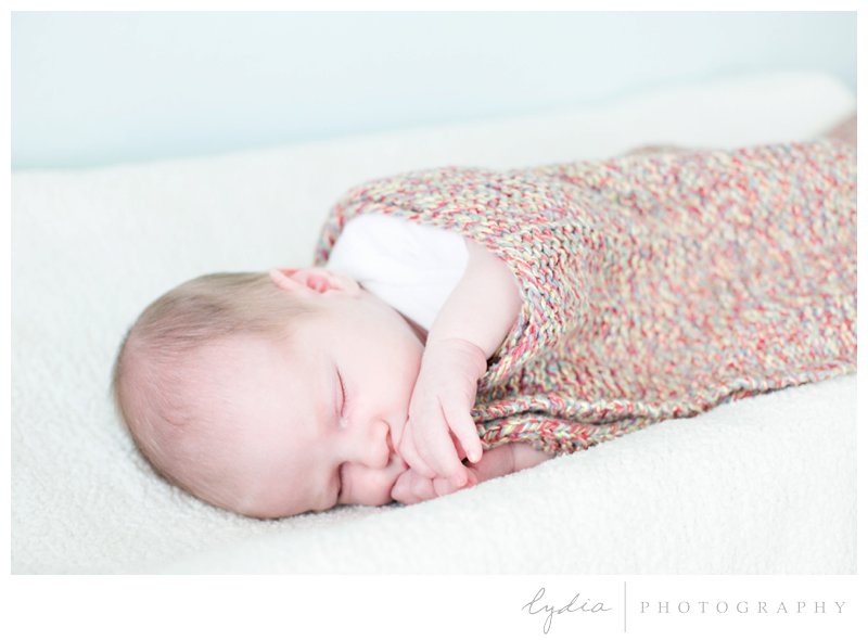 Baby wrapped in a handmade blanket for a lifestyle Napa newborn photography in California