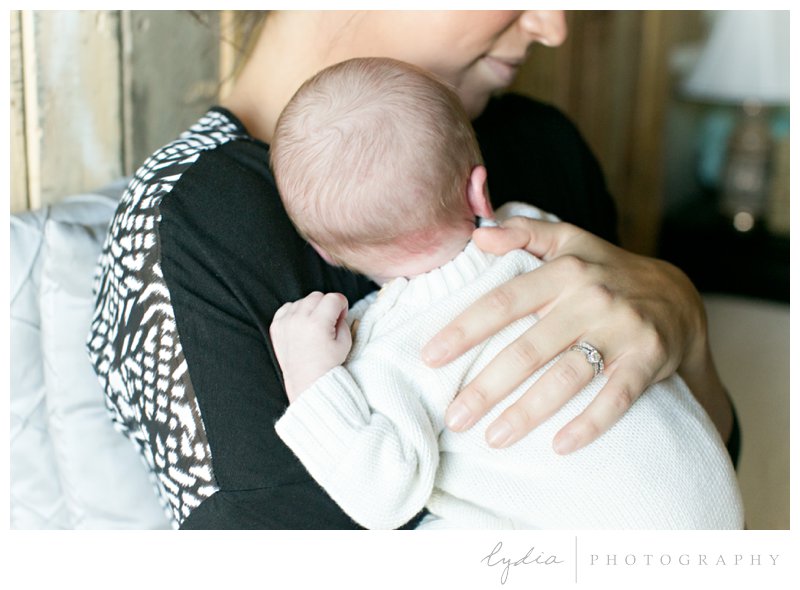 Baby in the arms of mother for a lifestyle newborn portraits in Roseville, California