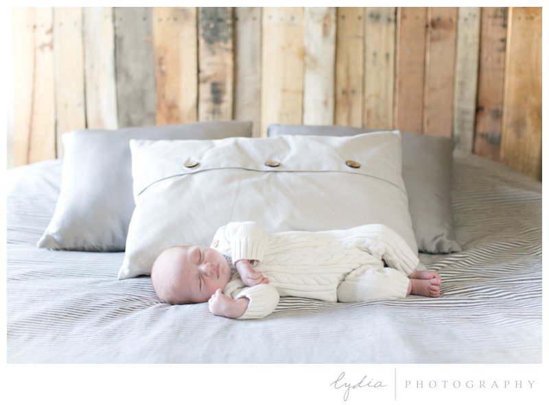 Baby on the bed for a lifestyle newborn portraits in Roseville, California