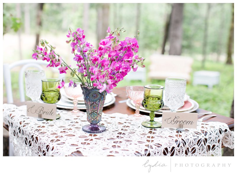 A sweetheart table for the bride and groom and vintage china with sweet peas for a forest barn wedding in Grass Valley, California.
