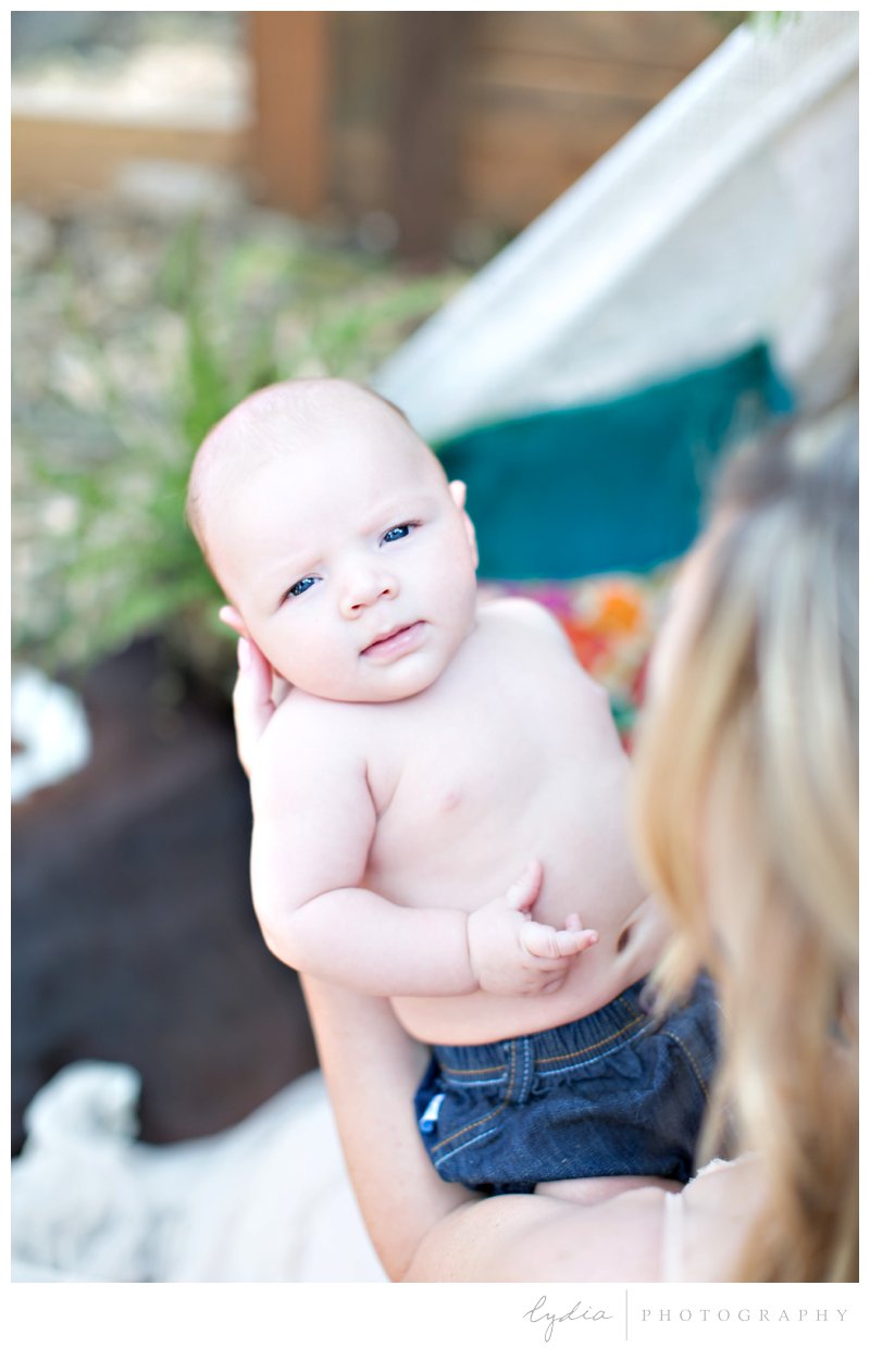 A baby in looking at the camera at southwest boho newborn inspiration in Grass Valley, California.