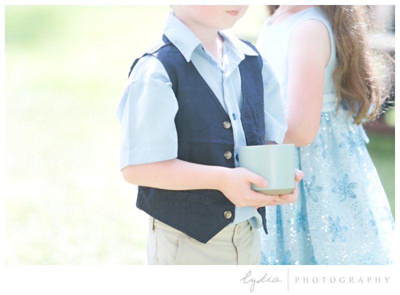 Ringbearers holding clay pots with rings at rustic garden wedding in Chicago Park, California.