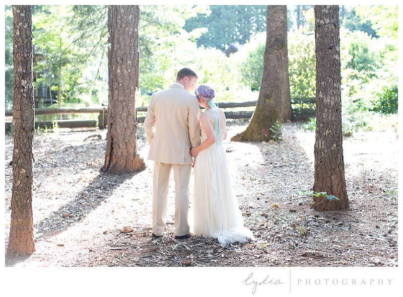 Bride leaning on groom in the woods at Harmony Ridge Lodge wedding in Grass Valley, California.