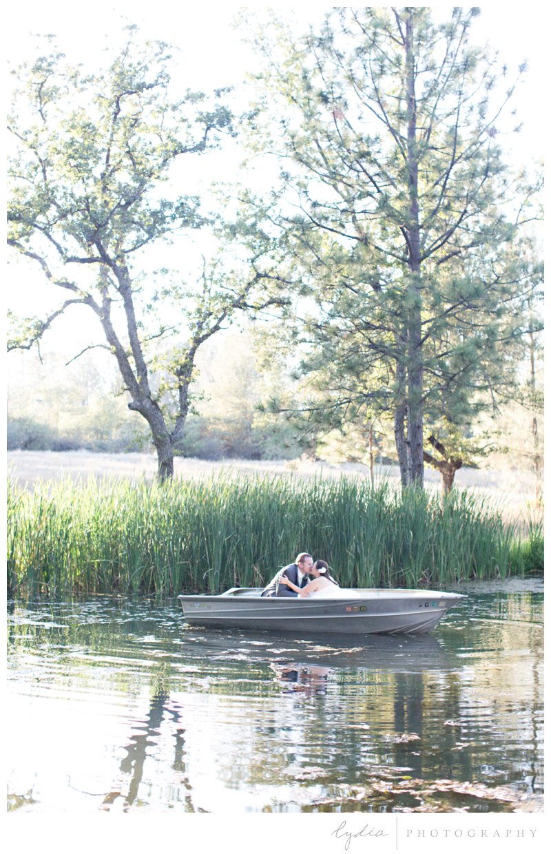 Bride and groom in a boat kissing at Squirrel Creek Ranch wedding in Grass Valley, California.