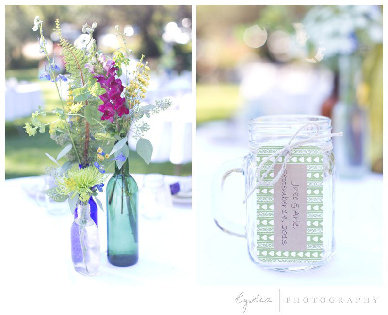 Flowers on a reception table and a jar with a name at a barn wedding at Squirrel Creek Ranch in Grass Valley, California.