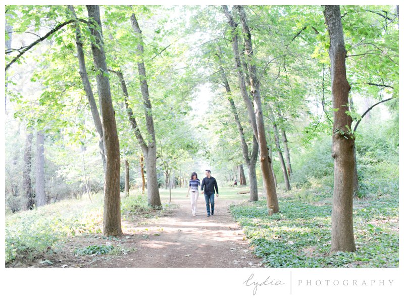 Bride and groom walking through a grove for Empire Mine engagement portraits in Grass Valley, California.