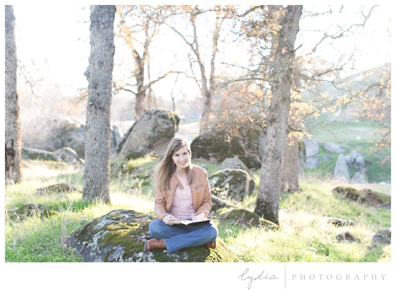Girl sitting out in nature journaling for BJU senior portraits at Whitney Oaks in Rocklin, California.