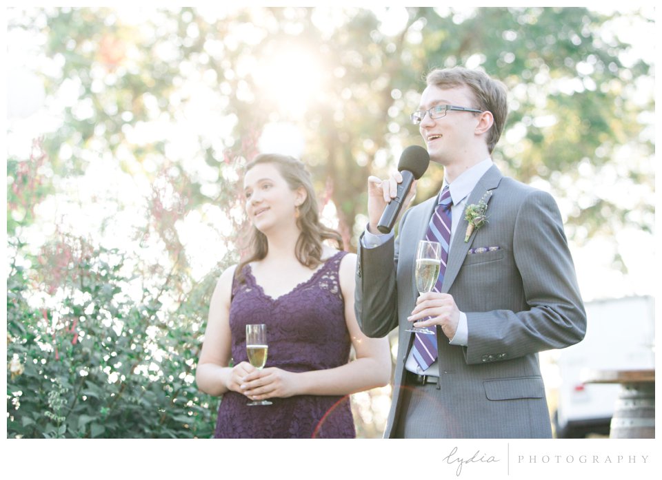 Groomsman and bridesmaid giving toasts at Lucchesi Vineyards in Grass Valley, California.
