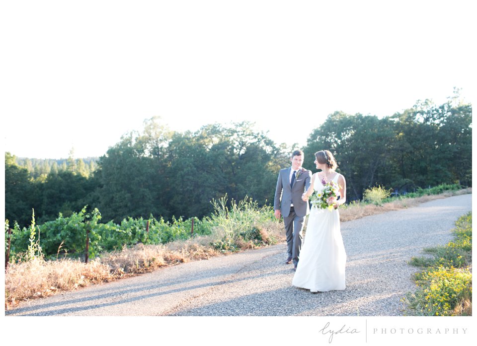 Bride and groom walking together at Lucchesi Vineyards wedding in Grass Valley, California.