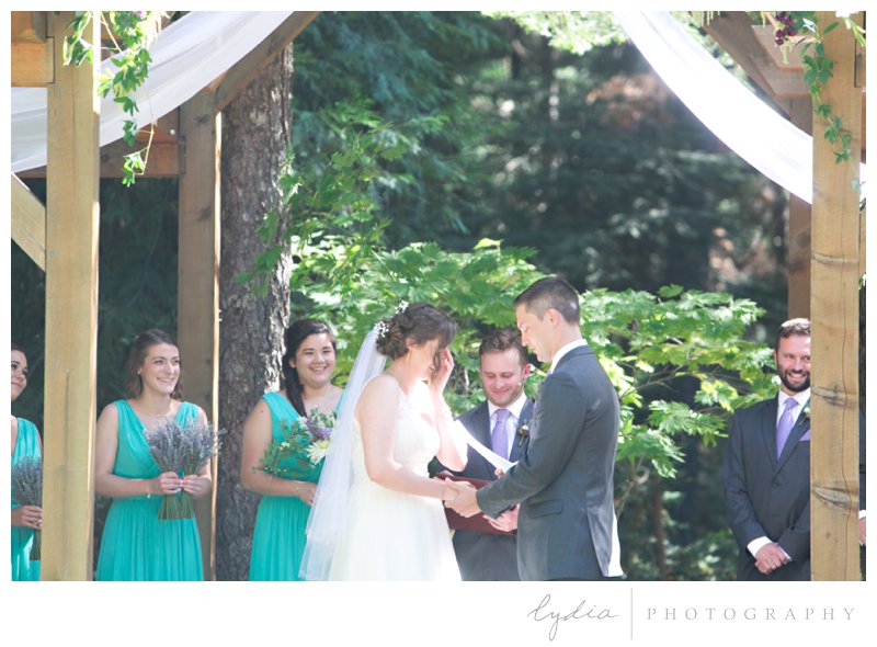 Bride and groom saying wedding vows during the ceremony in the Tahoe forest at Harmony Ridge Lodge in Nevada City, California.