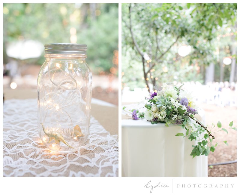 Lighted mason jars and bridal bouqet in the Tahoe forest at Harmony Ridge Lodge in Nevada City, California.