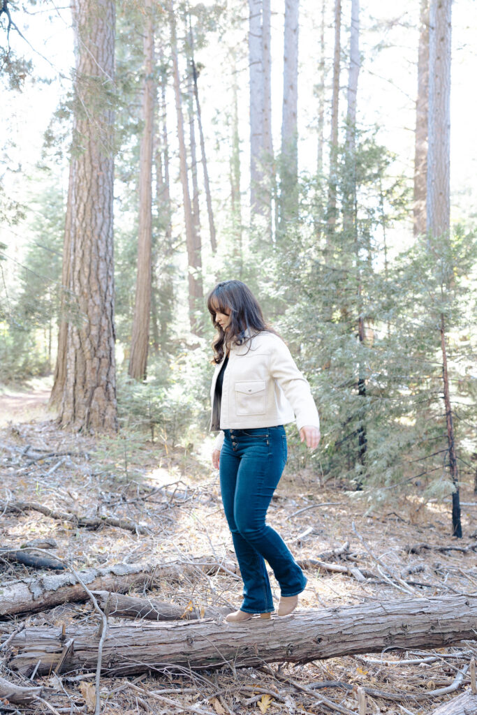 Teen girl walking on log at Nevada City senior portrait session.